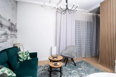 a living room with a green couch and a chair at krakow dream apartment in Kraków