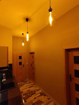 a room with three lights on the ceiling and a hallway at Little Big BC - Central Modern Studio in Kraków
