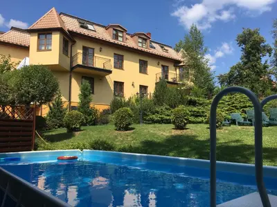 a swimming pool in front of a house at Villa Gorczańska in Rabka