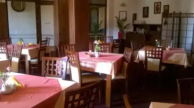 a restaurant with tables and chairs with pink table cloth at Villa Gorczańska in Rabka