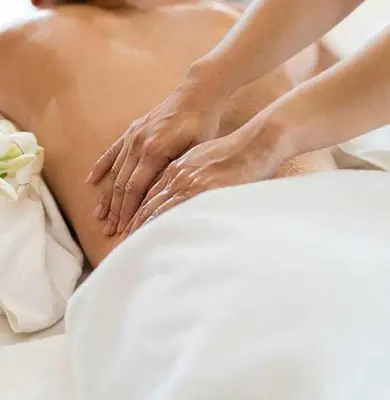 a woman getting a massage on her back in bed at Apartament Leśny in Nowy Targ