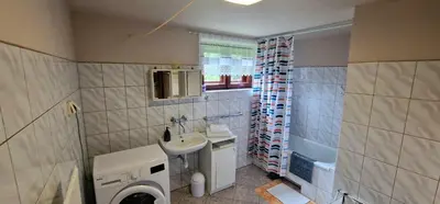 a bathroom with a sink and a washing machine at Apartament Leśny in Nowy Targ