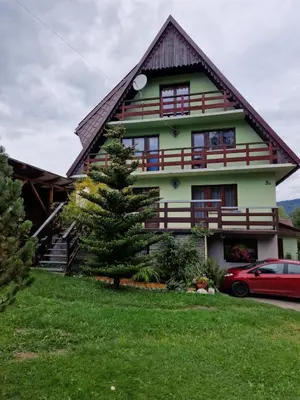 a house with a red car parked in front of it at Apartament Leśny in Nowy Targ
