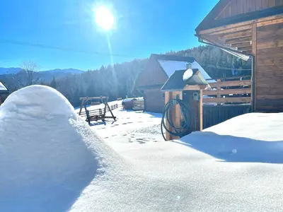 a snow covered fence in front of a cabin at Chatki Osada Babia Raj Zawoja in Zawoja
