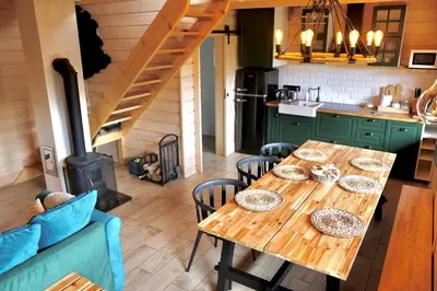a kitchen with a wooden table and a stove at Chatki Osada Babia Raj Zawoja in Zawoja