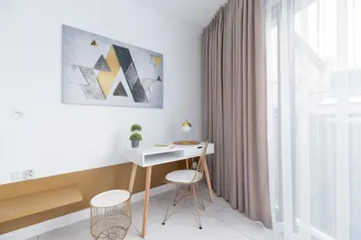 a desk and two chairs in a room with a window at Modern Apartment Cracow Old Town by Noclegi Renters in Kraków