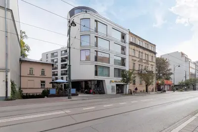 an empty street with a tall white building at Modern Apartment Cracow Old Town by Noclegi Renters in Kraków