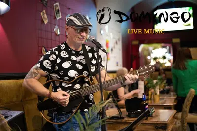 a man playing a guitar with a microphone at Otium Old Town Boutique in Kraków