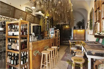 a restaurant with a bar with stools and wine bottles at Otium Old Town Boutique in Kraków