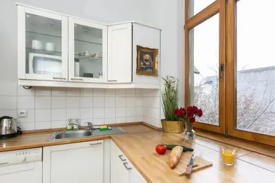 a kitchen with white cabinets and a wooden counter top at Otium Old Town Boutique in Kraków