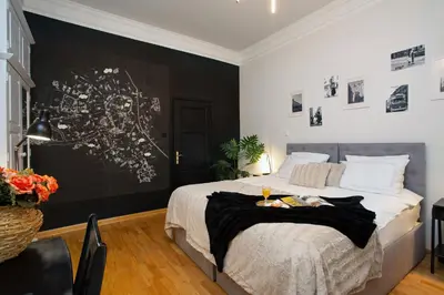 a bedroom with a bed with a black accent wall at Otium Old Town Boutique in Kraków