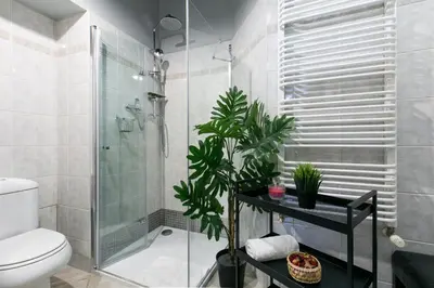 a bathroom with a shower and a toilet and plants at Otium Old Town Boutique in Kraków