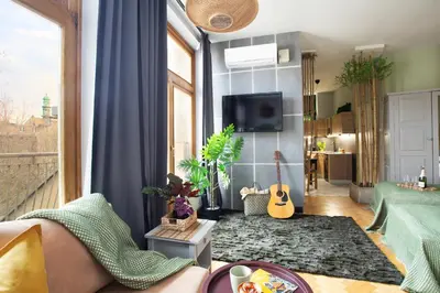 a living room with a couch and a guitar at Otium Old Town Boutique in Kraków