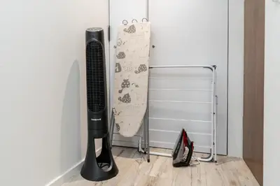 a black hair dryer next to a wall at Czarnowiejska Micro Studio in Kraków