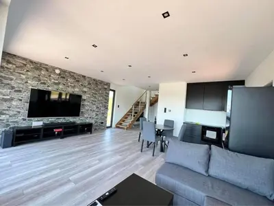 a living room with a couch and a stone wall at Wichrowe Wzgórze z jacuzzi in Znamirowice