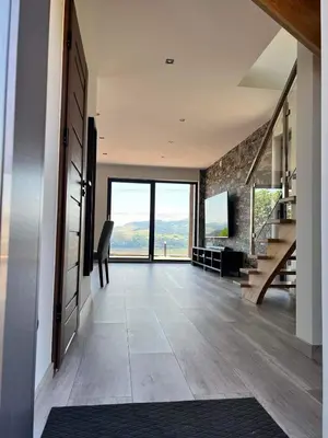 a living room with a staircase and a large window at Wichrowe Wzgórze z jacuzzi in Znamirowice