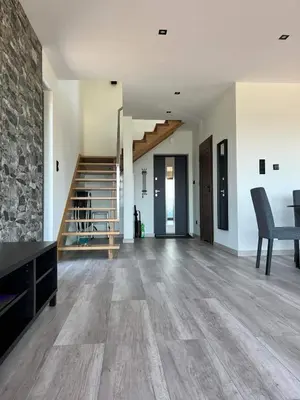 an empty living room with wooden floors and stairs at Wichrowe Wzgórze z jacuzzi in Znamirowice
