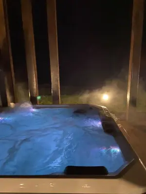 a jacuzzi tub in a backyard at night at Wichrowe Wzgórze z jacuzzi in Znamirowice