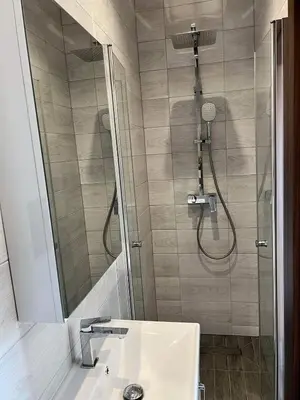 a bathroom with a shower and a white sink at Wichrowe Wzgórze z jacuzzi in Znamirowice