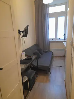 a room with a couch and a desk and a window at Baza wypadowa Kraków Kazimierz in Kraków