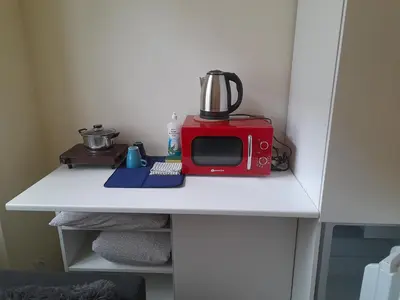 a red microwave sitting on top of a white table at Baza wypadowa Kraków Kazimierz in Kraków