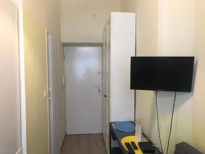 a room with a television on a wall with a door at Baza wypadowa Kraków Kazimierz in Kraków