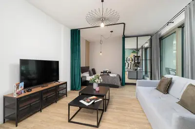 a living room with a couch and a tv at Kraków Rynek Podgórski Apartment by Noclegi Renters in Kraków