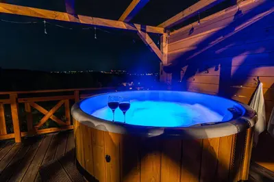 two wine glasses in a hot tub on a deck at Agroturystyka Góra Fiedora in Pieniążkowice