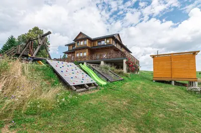 a house on a hill with a slide in front of it at Agroturystyka Góra Fiedora in Pieniążkowice