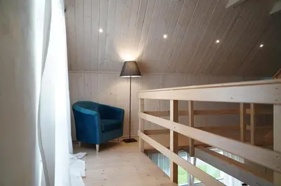 a room with a table and a blue chair and a lamp at Willa Sonia Zawoja in Zawoja