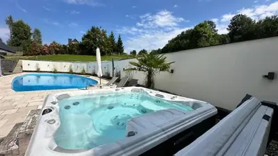 a hot tub sitting on a patio next to a pool at Willa Sonia Zawoja in Zawoja