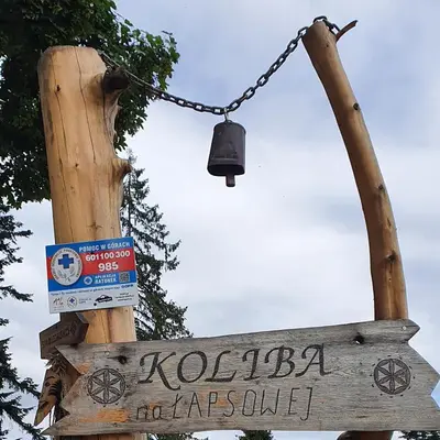 a street sign and a bell on a pole at Domek w górach pod Jodłami in Nowy Targ