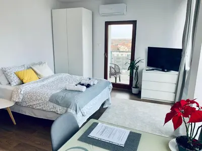 a bedroom with a bed and a tv and a table at City view Wellness Apartment swim&steam&relax in Kraków