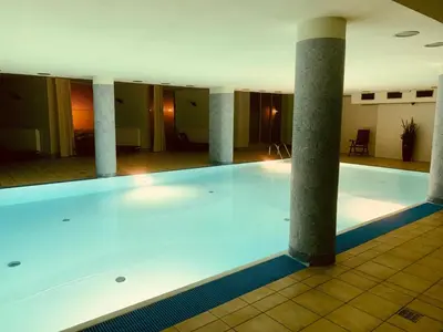 a large swimming pool in a building with columns at City view Wellness Apartment swim&steam&relax in Kraków