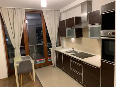 a kitchen with a sink and a counter with a window at City view Wellness Apartment swim&steam&relax in Kraków
