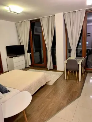 a bedroom with a bed and a desk and a television at City view Wellness Apartment swim&steam&relax in Kraków