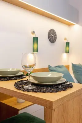 a table with a wine glass and plates on it at Kraków Trendy Studio Apartments by Noclegi Renters in Kraków