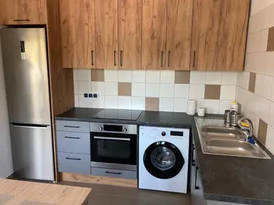 a kitchen with a washing machine and a sink at Hostel przy Stadionie in Jaworzno