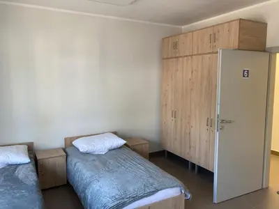 a bedroom with two beds and a closet at Hostel przy Stadionie in Jaworzno