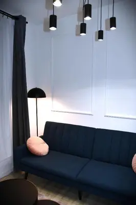 a blue couch in a living room with a lamp at M-Keys Apartments Kraków Old Town Kazimierz in Kraków