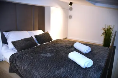 a large bed with two pillows on top of it at M-Keys Apartments Kraków Old Town Kazimierz in Kraków