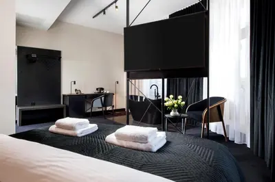 a bedroom with a bed with two towels on it at Hotel Krupnicza 30 in Kraków