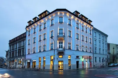 a large white building on the corner of a street at Hotel Krupnicza 30 in Kraków