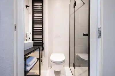 a bathroom with a toilet and a sink and a shower at Hotel Krupnicza 30 in Kraków