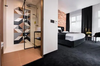 a hotel room with a bed and a bathroom at Hotel Krupnicza 30 in Kraków