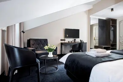 a hotel room with a bed and chairs and a desk at Hotel Krupnicza 30 in Kraków