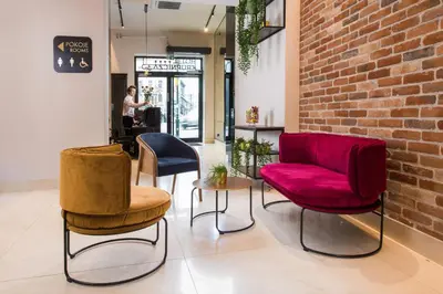 a room with three chairs and a brick wall at Hotel Krupnicza 30 in Kraków
