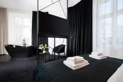 a bathroom with a bed with a tub and towels at Hotel Krupnicza 30 in Kraków