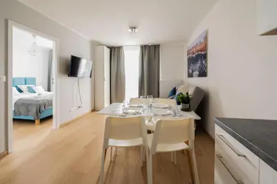 a dining room with a table and chairs and a bedroom at Sołtysowska Apartment in Kraków