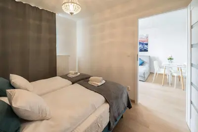 a bedroom with a bed and a dining room at Sołtysowska Apartment in Kraków